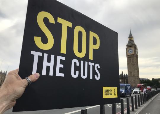 Stop the cuts placard held up outside big ben