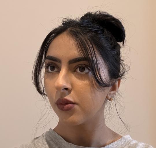 Image of Sukhjeen. She has her hair in a high bun and matte lipstick on